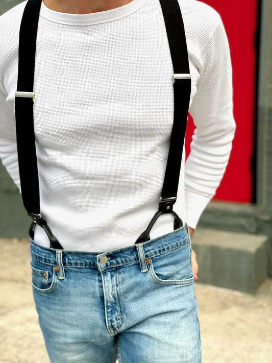 Close-up of black linen suspenders worn with light-wash jeans and white thermal shirt—handmade in Texas button-on braces for modern weddings and casual menswear styling.
